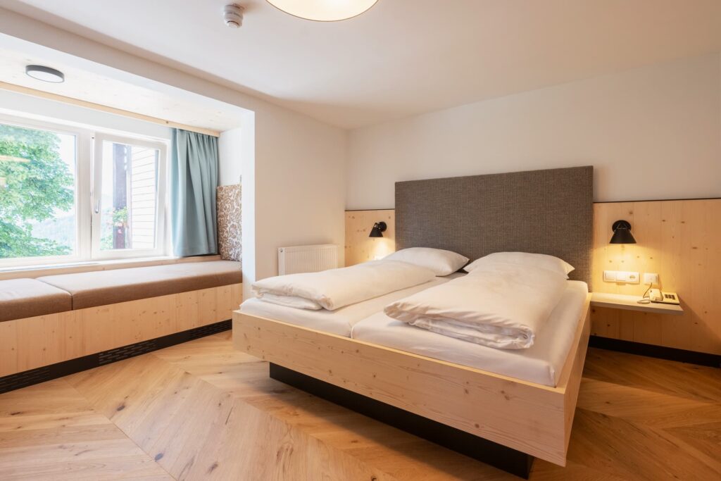 Bild vom Studio Lindenbaum im Schlafzimmer mit schönen Holzboden, Holzschiebetür und angenehmen warmen Licht