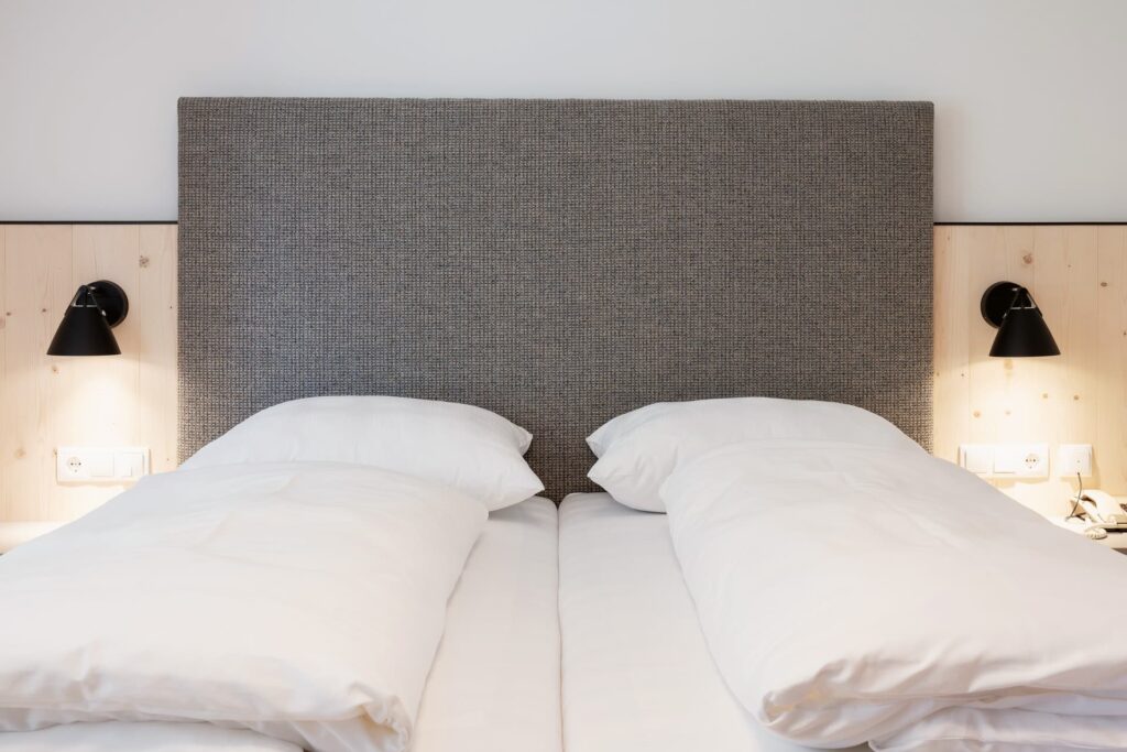 Bild vom Studio Lindenbaum Bett mit schöner Holzverkleidung und Lichter auf beiden Seiten