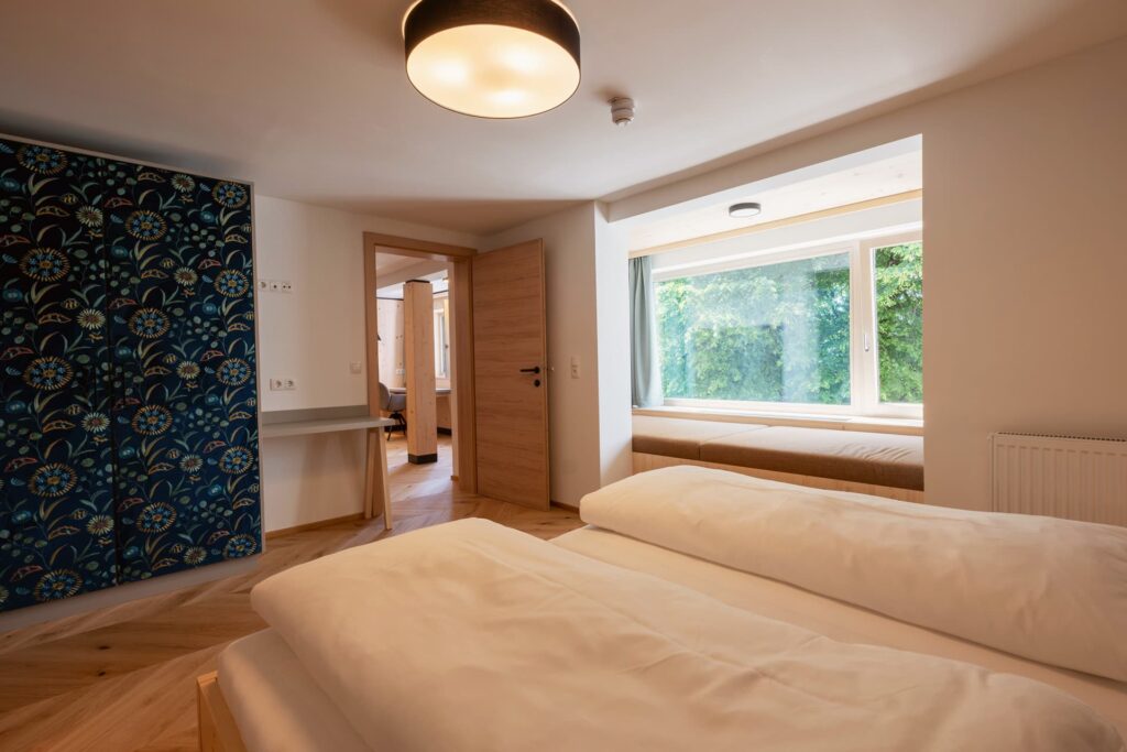 Bild vom Studio Lindenbaum, mit Bett und Sitzbank und großes Fenster