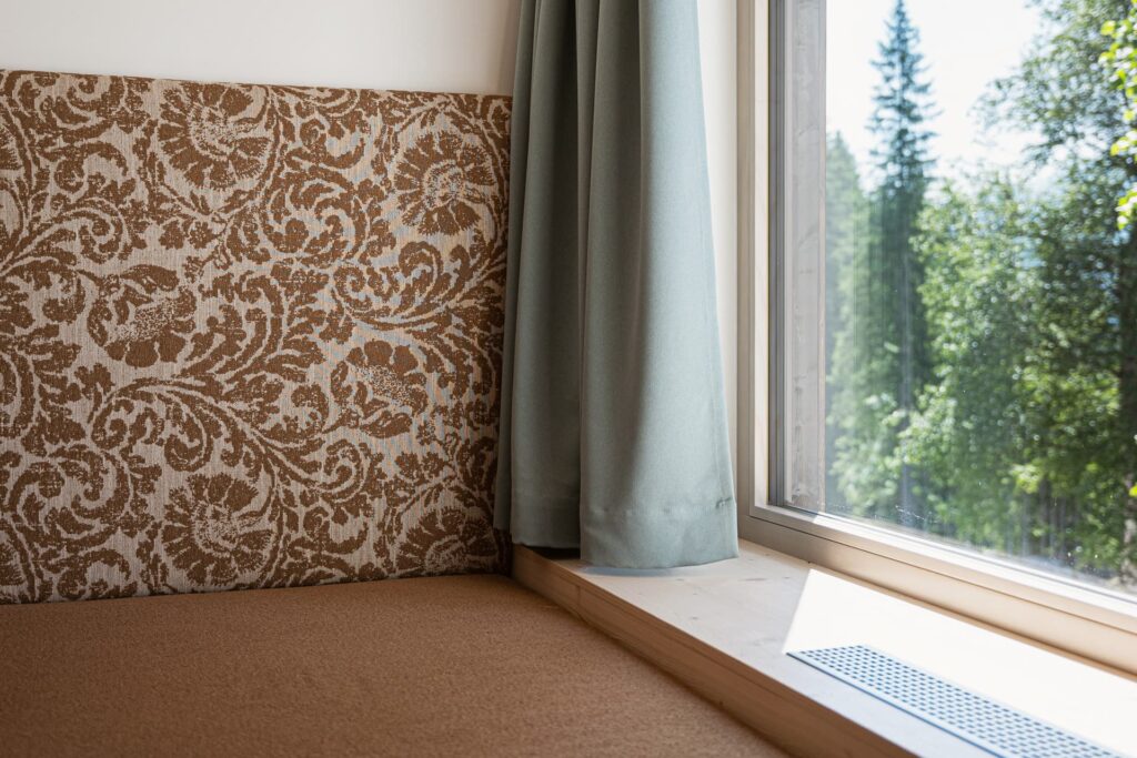 Bild vom Studio Lindenbaum, mit Sitzbank direkt beim Fenster mit Blick in das Grüne