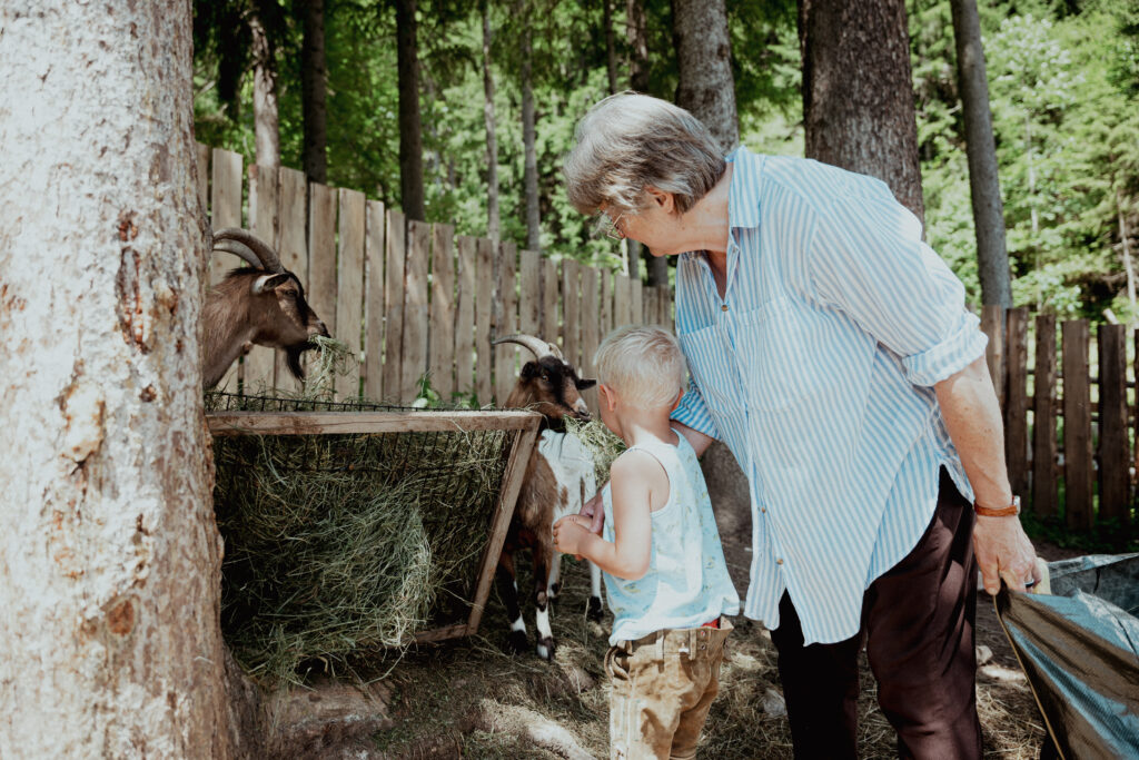 Anna Maria mit Kindern bei Ziegen